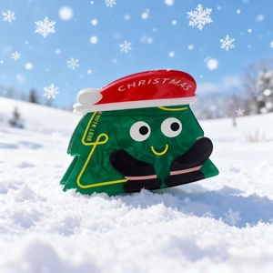 Pince à cheveux sapin de Noël avec visage souriant et bonnet sur fond de neige