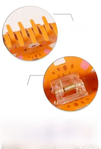 Macro detail of the orange tiger claw clip showing teeth and strong golden metal spring