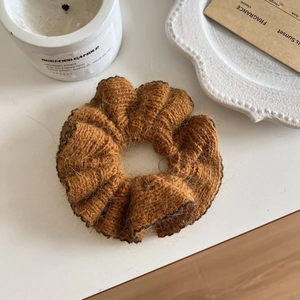 Macro detail of caramel brown knitted mohair scrunchie with soft fiber texture