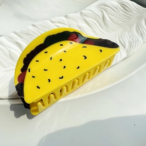 Pince à cheveux vive en forme de taco en résine acrylique sur un plateau blanc