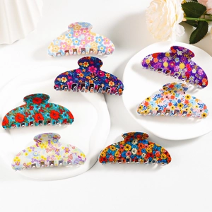 Set of 6 large floral hair claw clips with various daisy patterns on a white tray