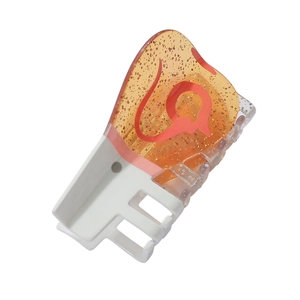 Close-up of acetic acid hair claw clip with orange glitter and red wavy patterns