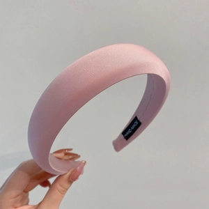 Detailed view of pink satin padded headband with premium handmade label and stitching