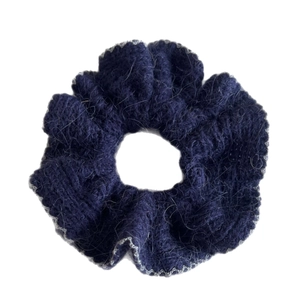 Navy blue fluffy knitted scrunchie with grey lace trim on a clean white background