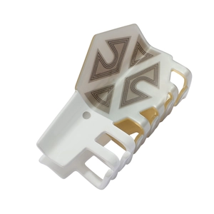 Detail view of large acetate hair claw clip with cream and taupe geometric pattern