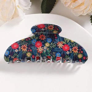 Macro shot of large floral shark clip with colorful small daisies on dark blue base