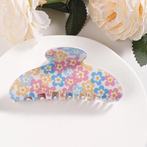 Detail shot of a floral print claw clip with blue and yellow daisy patterns