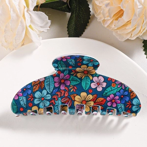 Macro view of large hair claw clip featuring vibrant multi-color floral print patterns