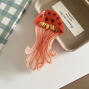 Macro detail of jellyfish hair claw clip with floral patterns and vibrant orange gradient