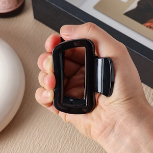 Large square black silicone hair claw clip held by hand for thick long hair styling
