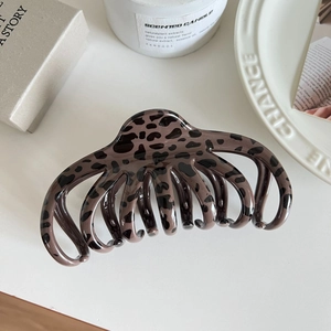 Dettaglio della grande molletta per capelli leopardata con denti multipli per capelli folti