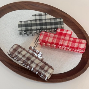 Three oversized retro plaid acetate hair claws in classic British checkered patterns