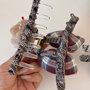 Detail of plaid fabric hair claw clip with plush bear doll and red-green checkered bows