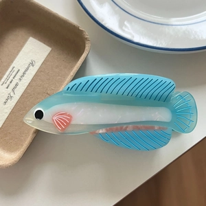 Detail view of a creative fish-shaped acetate hair claw clip with a jelly texture finish