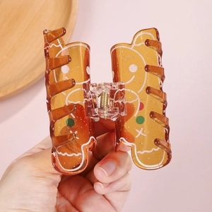 Λεπτομέρεια κλιπ μαλλιών ανθρωπάκι gingerbread από κεχριμπαρένια ρητίνη με γκλίτερ