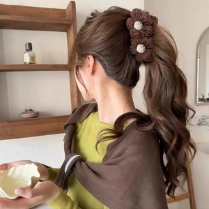 Pince à cheveux fleur tricotée marron pour queue de cheval sur un mannequin