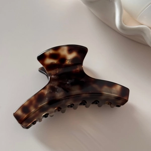 Detailed view of large tortoiseshell acetate hair claw clip with vintage brown pattern
