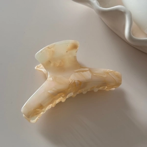 Detailed view of large marble texture acetate hair claw clip for elegant hair styling