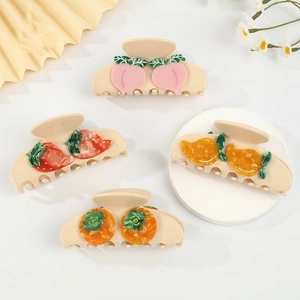 Detail showing four assorted fruit hair claws including strawberry and peach designs