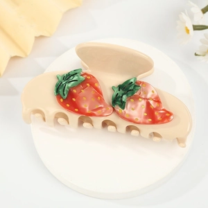 Sweet cream-colored hair claw clip with red strawberry motifs on a clean white display