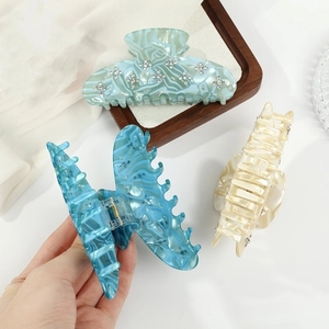 Elegant acetate claw clips with diamond accents in blue and cream marble finishes