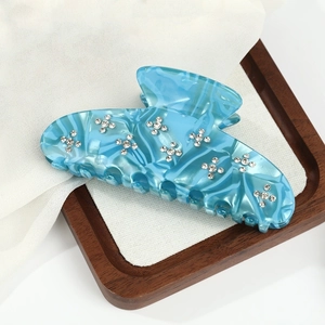 Detail of blue marble cellulose acetate hair claw clip with sparkling rhinestones
