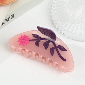 Nahaufnahme einer rosa durchsichtigen Haarspange aus Acetat mit Blumen auf einem Tisch