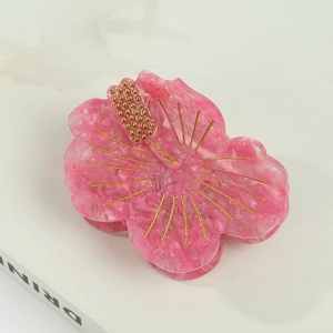 Pink acetate flower hair claw clip with floral marble texture and golden core detail
