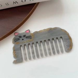 Gros plan du peigne à dents larges en forme de chat avec motif marbre gris en acétate
