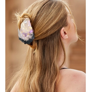 Iridescent shell-shaped acetate hair claw with pearl accent on elegant half-up hairstyle