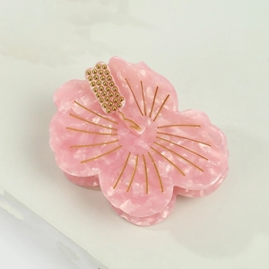 Pink hibiscus flower hair claw clip with marble texture and golden bead center details