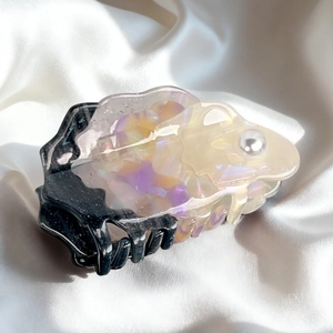 Elegant acetate shark hair claw clip with colorful marble pattern and pearl detail on silk
