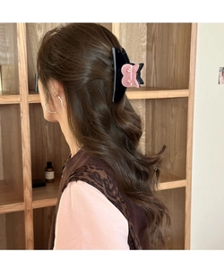 Détail de la pince à cheveux oreilles de chat avec strass roses sur acétate noir poli