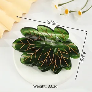 Pince à cheveux feuille verte avec nervures dorées sur socle blanc 9.6cm
