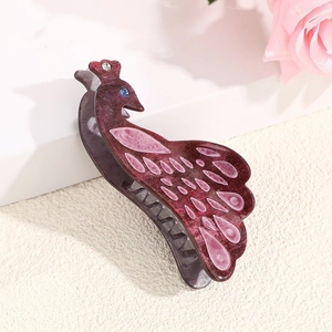 Detailed view of elegant peacock hair claw clip with purple acetate finish and rhinestones