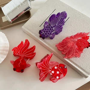Elegant goldfish-shaped acetate hair claws in purple and red for thick hair styling