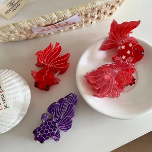 Elegant goldfish-shaped acetate hair claw clips in various colors for stylish updos