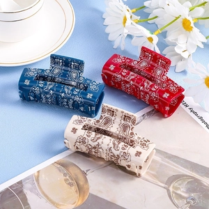 Three rectangular paisley hair claw clips in blue, red and cream with floral decor
