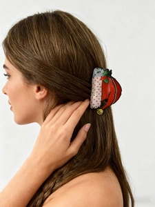 Detailed view of a festive Christmas hat hair claw clip with bells on a female model