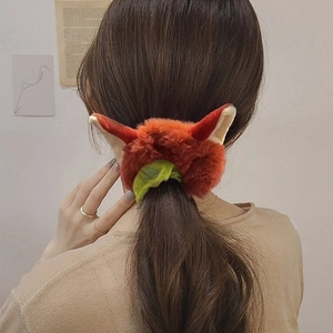 Chouchou peluche oreilles de renard orange et vert porté sur une queue de cheval