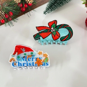 Detail view of festive Christmas hair claws with Santa hat and gingerbread patterns