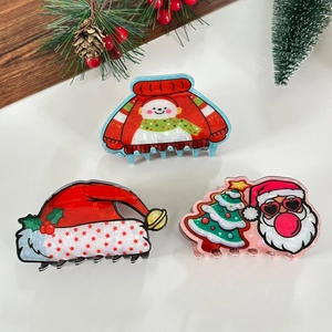 Detailed view of Christmas hair claws featuring Santa Claus and snowman patterns
