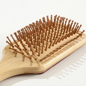 Close-up of bamboo massage hairbrush with natural grain and smooth round-tip bristles