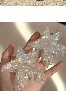 Macro shot of colorful iridescent starfish hair claws with sparkling rhinestones decoration