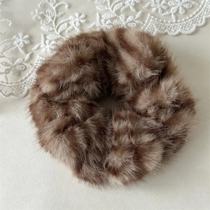 Detailed macro view of the fluffy brown zebra pattern plush scrunchie on lace background