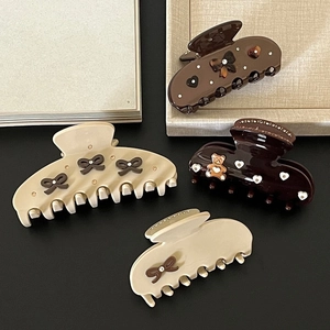 Brown bow hair claw clips set with rhinestone accents and cream heart decorations