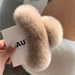 Détail d'une grande pince à cheveux en fausse fourrure de lapin beige pour chignons élégants