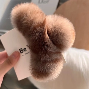 Détail d'une pince à cheveux en fausse fourrure de lapin marron café et texture peluche