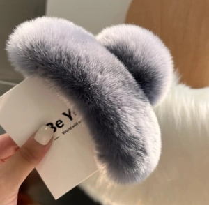 Détail d'une grande pince à cheveux en fausse fourrure de lapin douce couleur bleu poudré