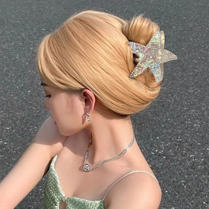 Iridescent starfish hair claw clip with rhinestones worn for an elegant hairstyle